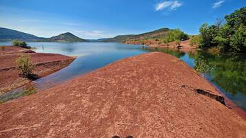 A river with red soil banks and a clear blue sky.
