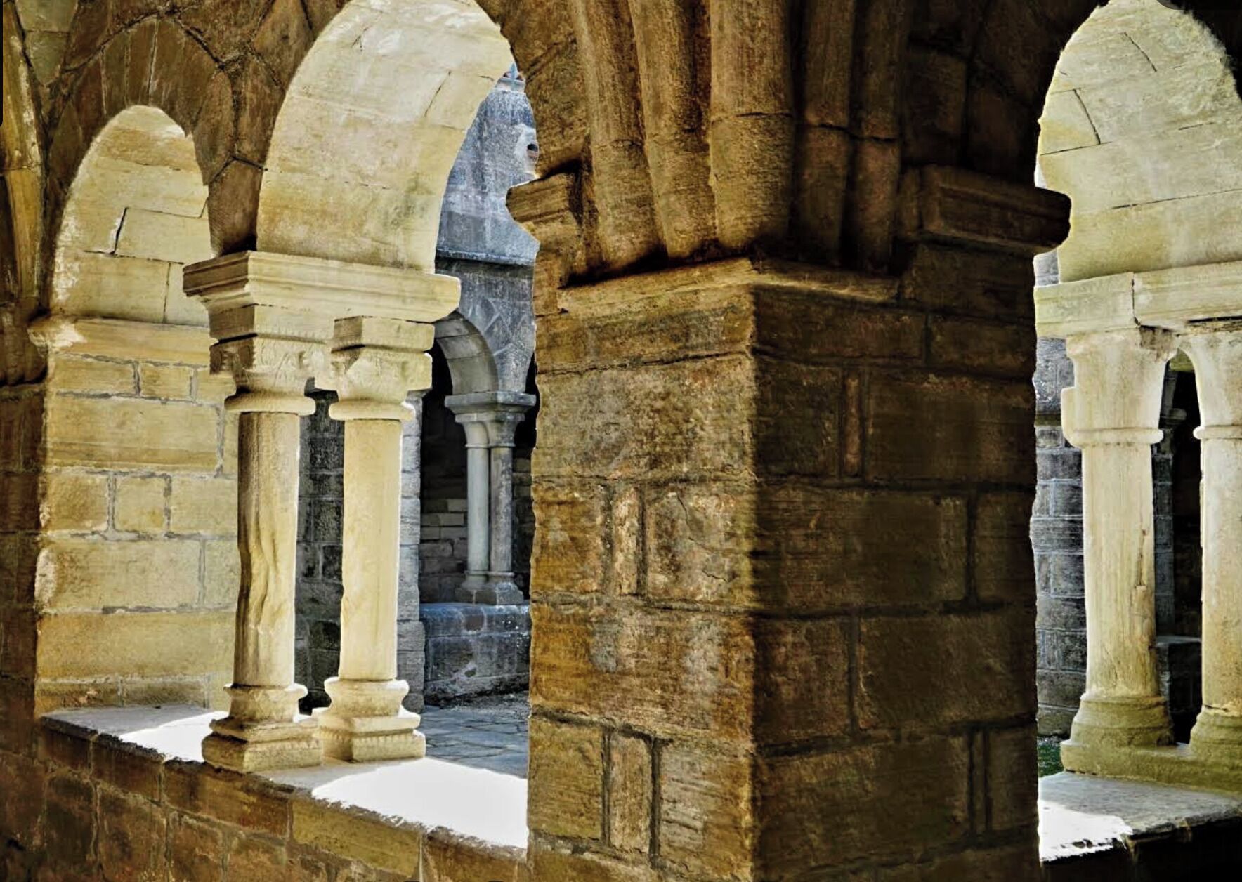 Une arche en pierre, soutenue par des colonnes, qui fait partie de l’architecture d’un bâtiment historique.
