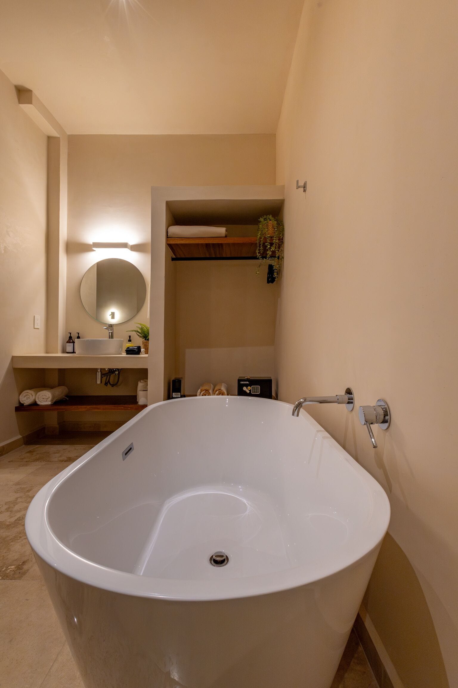 Ein modernes Badezimmer mit einer freistehenden Badewanne, einem Waschtisch mit Spiegel und einem Handtuchhalter.