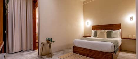 Un dormitorio con una cama de madera, una mesita de noche pequeña, un aire acondicionado instalado en la pared y un aparato de luz.