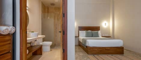 Un dormitorio moderno con cabecera de madera, cama blanca y mesita de noche.