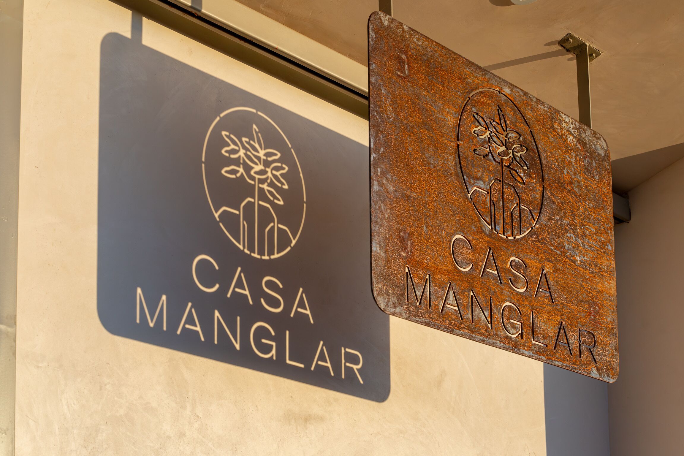 Dos letreros de 'Casa Manglar' con un logotipo y texto.
