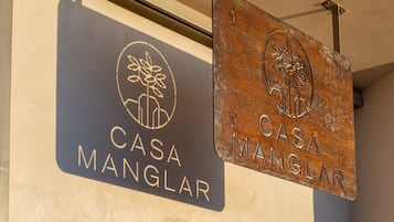 Two signs for 'Casa Manglar' with a logo and text.