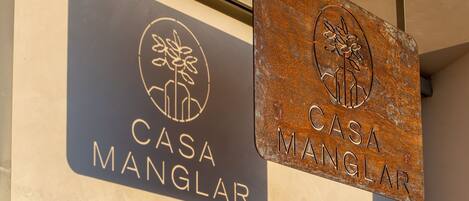 Dos letreros de 'Casa Manglar' con un logotipo y texto.
