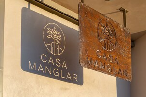 Dos letreros de 'Casa Manglar' con un logotipo y texto.