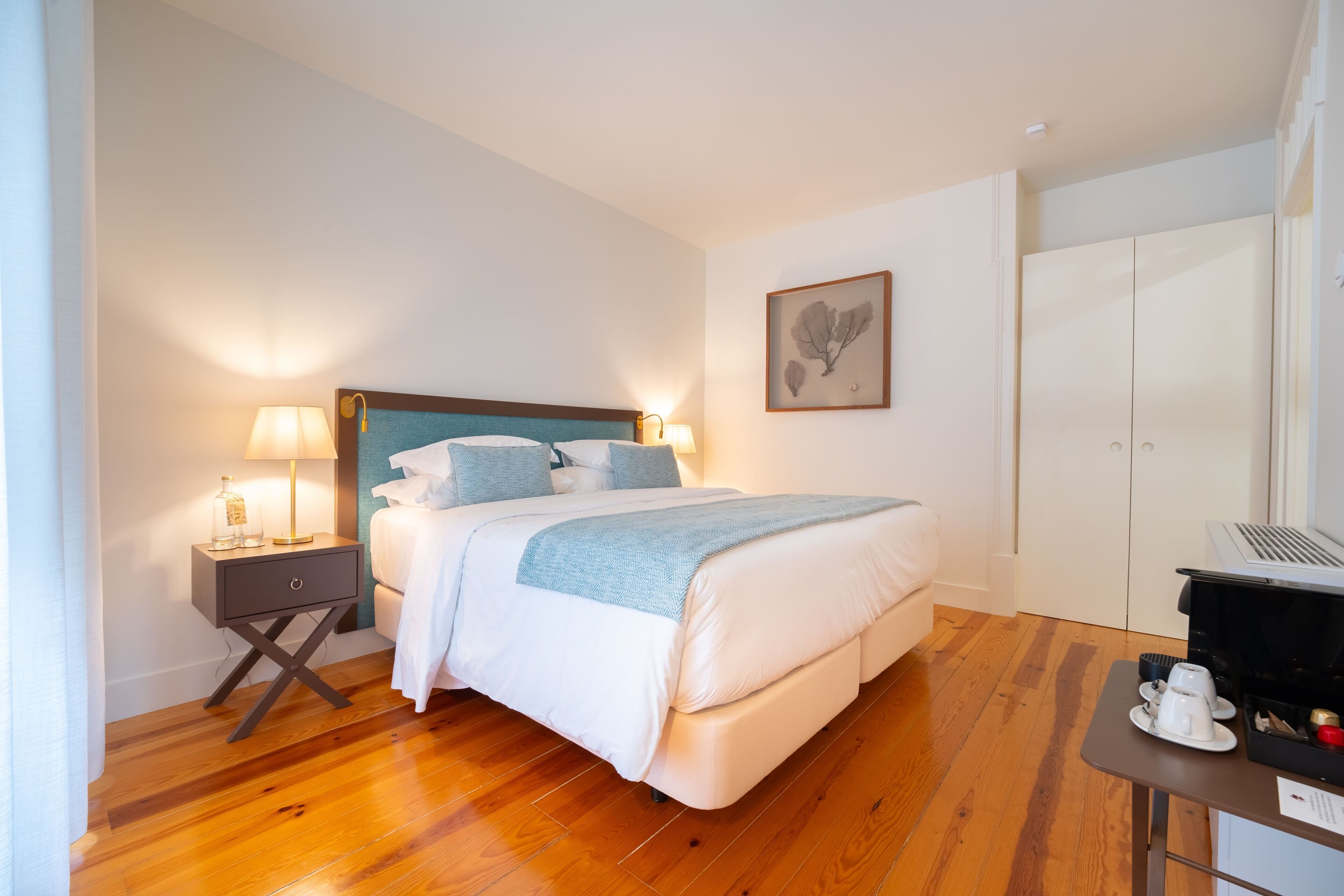 Une chambre bien rangée, avec un lit, des tables de chevet, un bureau avec un ordinateur portable et une armoire.