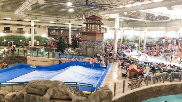 An indoor water park with multiple pools, a central pavilion, and a variety of seating areas. - Charming Mpls Escape - Sleeps 14 (Minneapolis)
