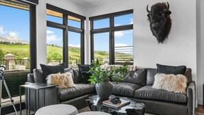 Ein modernes Wohnzimmer mit Ledersofa, Couchtisch und einem aufgehängten Tierkopf.