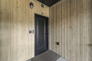 A wooden door with the number 31, a small light above it, and a doormat in front.
