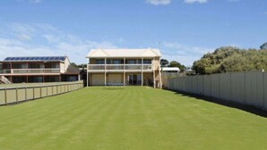A building with a flat roof, a balcony, and a staircase leading to the entrance. - Hindmarsh Hideaway-—Waterfront Pet-friendly Living (Hindmarsh Island)