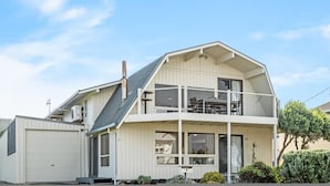 A two-story house with a balcony, large windows, and a garage.