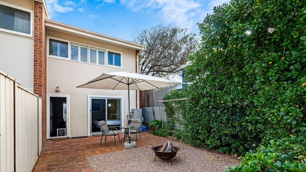 A patio with a fire pit, outdoor furniture, and a covered seating area.