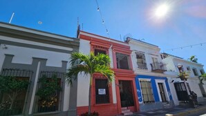 Calle con edificios pintados de blanco, rojo y azul.