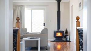 Een woonkamer met een moderne open haard, een bank en een salontafel.