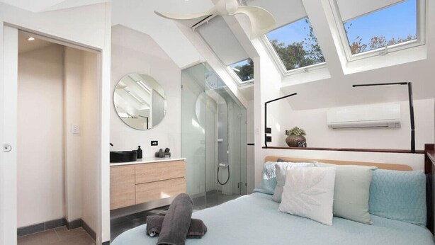 A modern bedroom with a skylight, a large bed, a walk-in closet, and a bathroom with a glass shower. - The Gordon Hideaway, Heart of Glenelg, Luxury (Glenelg)