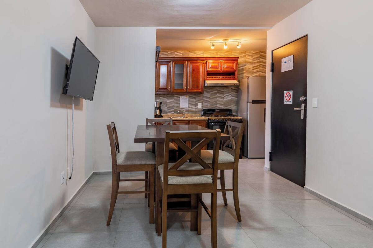 A compact kitchen with wooden cabinets, a built-in stove, and a refrigerator.