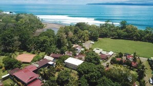 An aerial view of a coastal residential area with houses, greenery, and a beach. - Charming 2-bedroom house with WiFi, AC in Pavones (Pavones)
