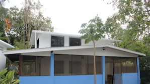 A modern two-story house with large windows and a covered porch. - Charming 2-bedroom house with WiFi, AC in Pavones (Pavones)