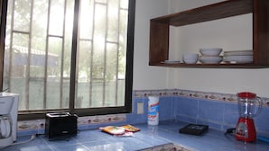 A kitchen with a window, a blender, a coffee maker, and a bag of chips. - Charming 2-bedroom house with WiFi, AC in Pavones (Pavones)