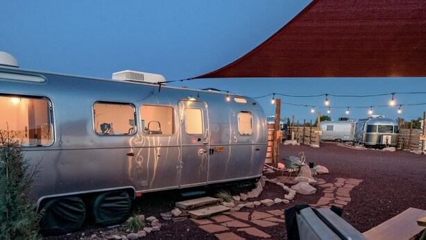 A silver recreational vehicle with a hot tub in the foreground.