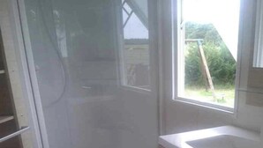 A bathroom with a shower, toilet, and sink. - Mobile home 32m2 at the farm (Souvigny-en-Sologne)