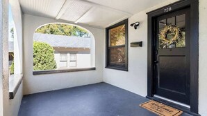 A black door with a wreath, a welcome mat, and a number 728 on the wall. - Charming 2-bedroom Home Lakeland (Lakeland)