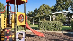 Une aire de jeux avec un toboggan, des structures d’escalade et un espace abrité.