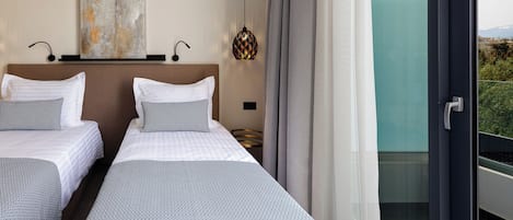 A hotel room with two beds, a large window, and a view of the outdoors.