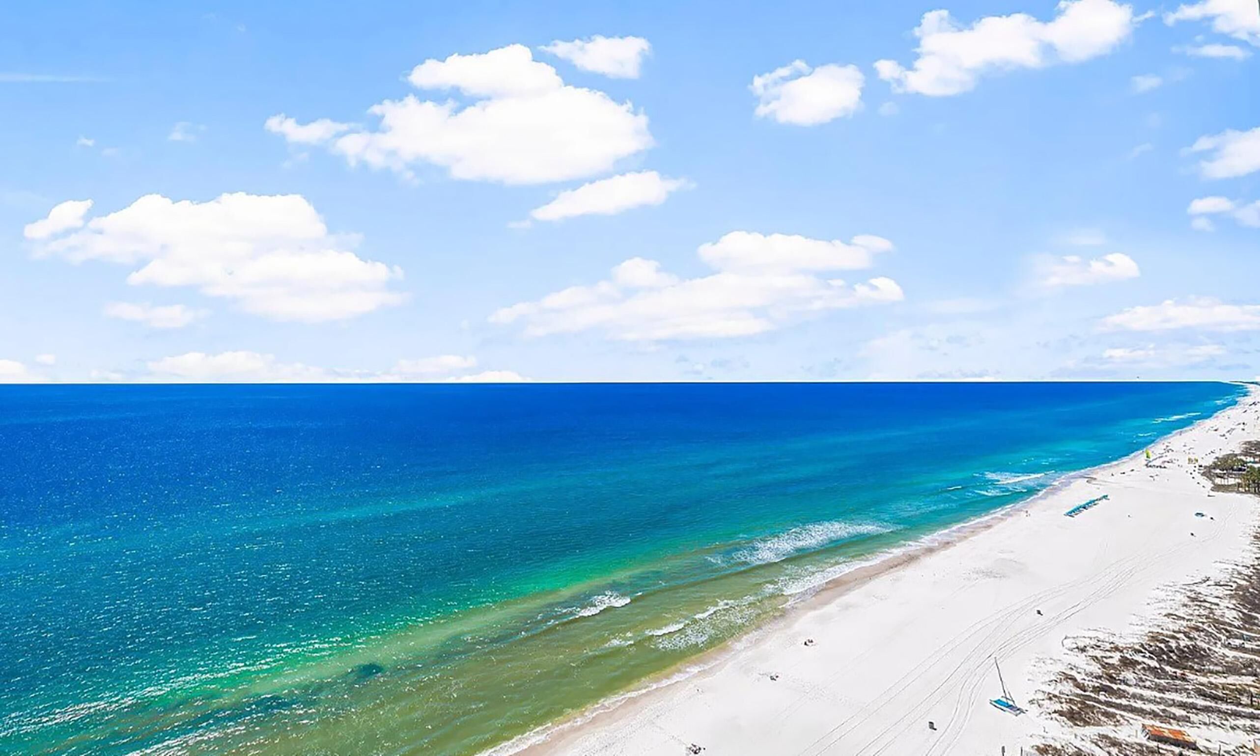 Una playa con aguas turquesas cristalinas y una orilla de arena blanca.