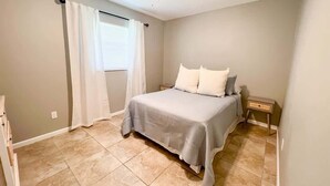 A bedroom with a bed, a nightstand, a ceiling fan, and a window with curtains. - Cozy 2 Bedroom Home, Dade City! #2 (Dade City)