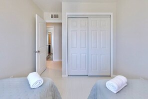 A hotel room with two beds, a wardrobe, and a hallway leading to another room. - Brooksville Retreat! 3 Bed, 2 Bath! (Brooksville)