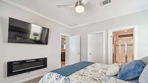 A bedroom with a bed, a flat-screen TV mounted on the wall, and a ceiling fan. - 2 Bed Cozy Home, Dade City, Pickle Ball (Dade City)