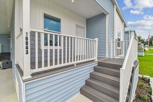 A residential house with a front porch, a staircase, and a mailbox.