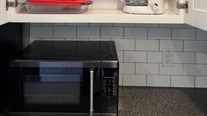 A kitchen with a microwave, a toaster, and a coffee maker on the countertop. - Contemporary 3 Bedroom Home in Dade City (Dade City)