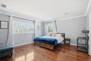 A bedroom with a bed, a bench, a nightstand, and a shelf. - Executive 5 Bedroom Pool Home, Dade City! (Dade City)