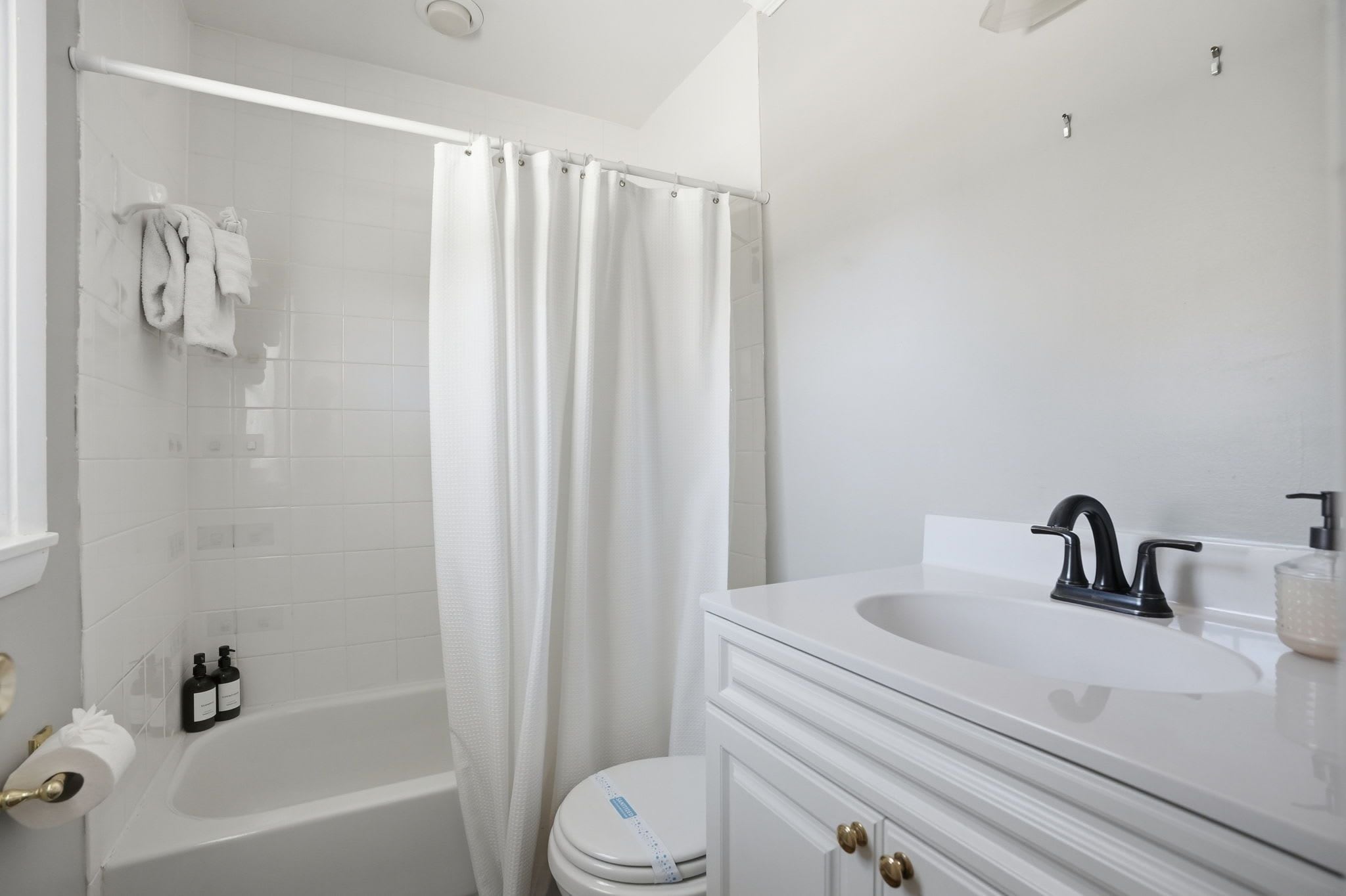A bathroom with a bathtub, toilet, and sink.