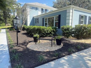 A modern house with a well-maintained garden, including a bench and potted plants. - Executive 5 Bedroom Pool Home, Dade City! (Dade City)