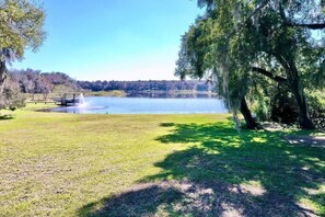 A serene lakeside setting with a gazebo and a large tree. - Executive 5 Bedroom Pool Home, Dade City! (Dade City)