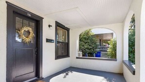 A house entrance with a dark door, a welcome mat, a wreath, and a window overlooking a garden. - Charming 1-bedroom Home in Lakeland! (Lakeland)
