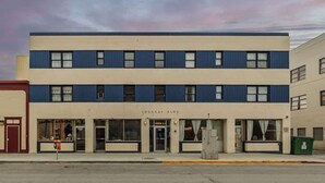 A two-story building with a flat facade, large windows, and a sign reading "LOUSSAI BLDG." - Historical Art Deco Central Downtown - Sleeps 4 (Anchorage)