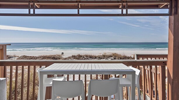 A beach view from a covered deck with a table and chairs. - Gulfs Edge Townhome #7- Sun-kissed Memories (Panama City Beach)
