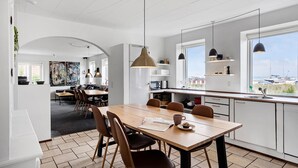 A modern kitchen with a dining area, large windows, and a view of the sea. - 6 bedroom amazing home in Glesborg (Glesborg)