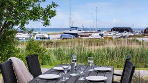 A table set for dining with a view of a marina and boats. - 6 bedroom amazing home in Glesborg (Glesborg)