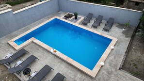 Kolam renang outdoor musiman, dengan kursi berjemur