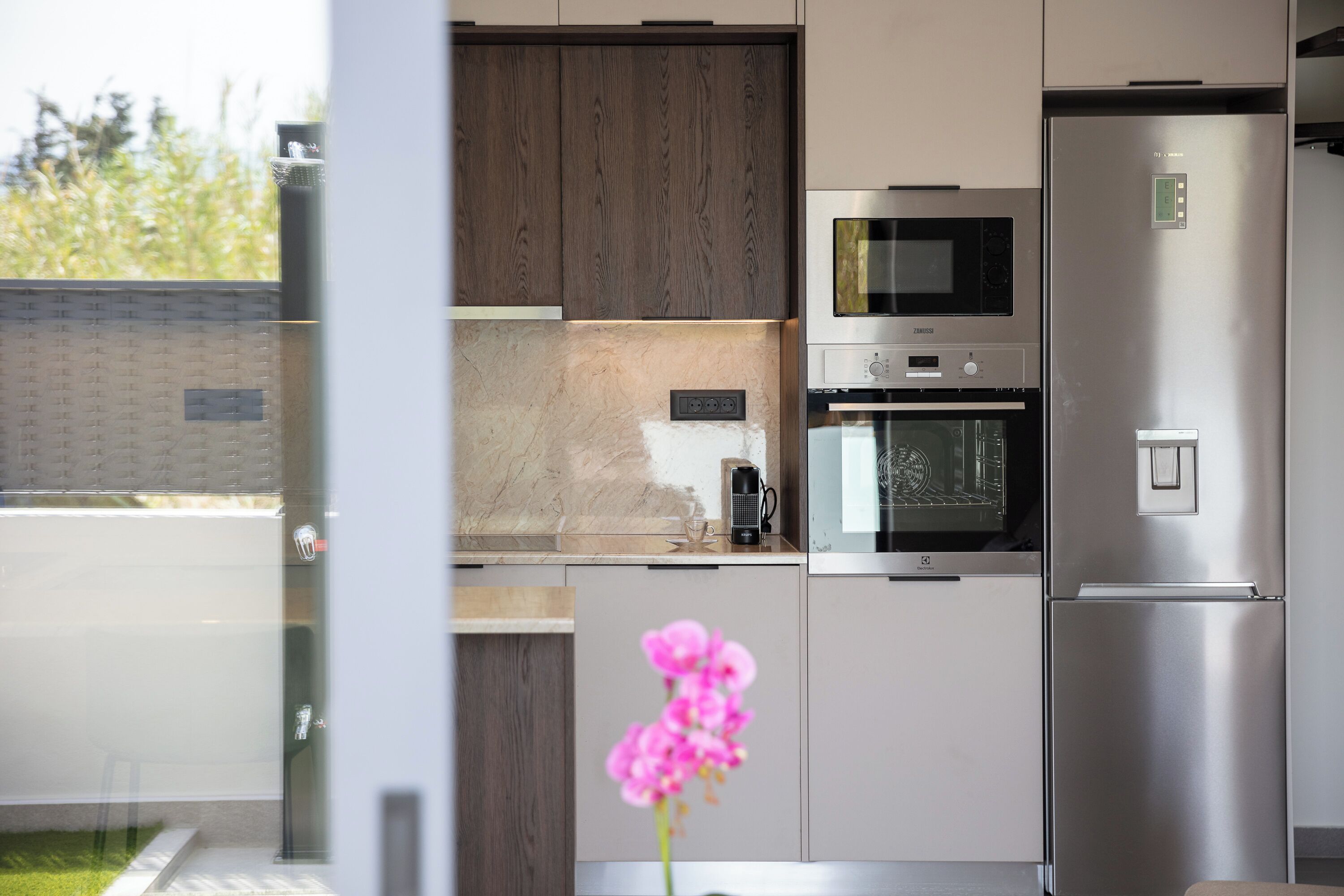 Una cocina moderna con electrodomésticos de acero inoxidable, microondas y horno empotrado.