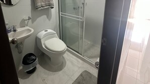 A modern bathroom with a glass-enclosed shower, a sink, and a toilet. - FURNISHED APARTMENT IN SOTOMAYOR CABECERA (Bucaramanga)