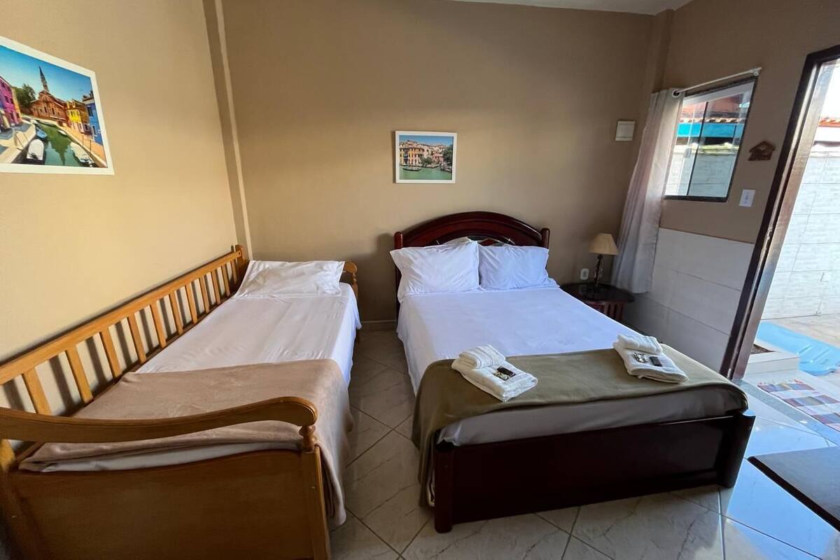 Ett hotellrum med två separata sängar, en sänggavel i trä, ett litet bord och ett fönster med utsikt.