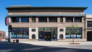A two-story building with a brick facade, large windows, and a sign for a dental clinic. - The Intrepid (Duluth)