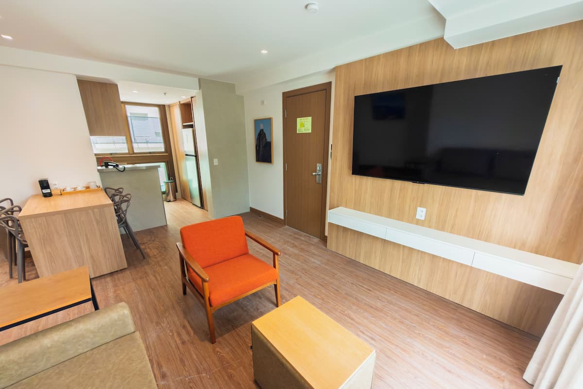 Apartamento família, 2 quartos, sacada | Sala de estar | TV 40 polegadas com canais a cabo