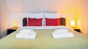 A hotel room with a neatly made bed, two pillows, and two bedside lamps. - Zwart Janstraat  (Rotterdam)